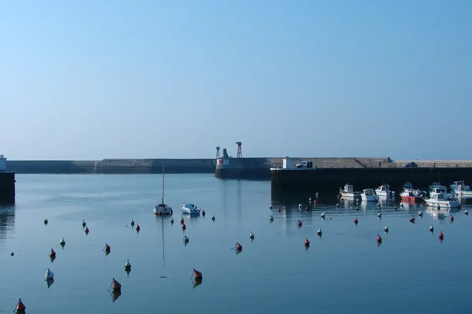 Le port de Port-en-Bessin-Huppain, avec ses chalutiers amarrés et les maisons de pierre autour du bassin